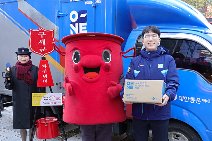 CJ대한통운 오네(O-NE) 배송차량 앞에서 CJ대한통운 직원과 구세군 사관, 구세군 캐릭터 따끈이가 10주년 기념촬영을 하고 있다.(사진=CJ대한통운)