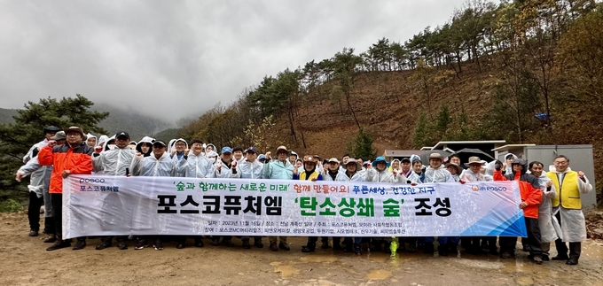 포스코퓨처엠 임직원들이 탄소중립 실천을 위해 지난 11월 광양공장 인근 계족산에서 탄소상쇄 숲을 조성한 후 기념 촬영을 하고 있는 장면(사진=포스코퓨어엠)