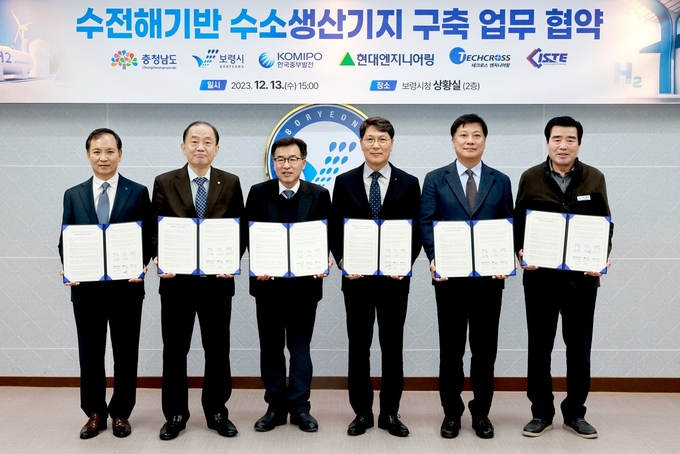 지난 13일 진행된 <보령 수전해 기반 수소생산기지 구축> 사업협약식에 참석한 관계자들이 기념사진을 촬영하고 있다. (왼쪽부터) 김정철 테크로스 워터앤에너지 대표, 김호빈 한국중부발전 사장, 전형식 충남도 정무부지사, 홍현성 현대엔지니어링 대표이사, 박성수 아이에스티이 부사장, 김동일 보령시장)(사진=현대엔지니어링)
