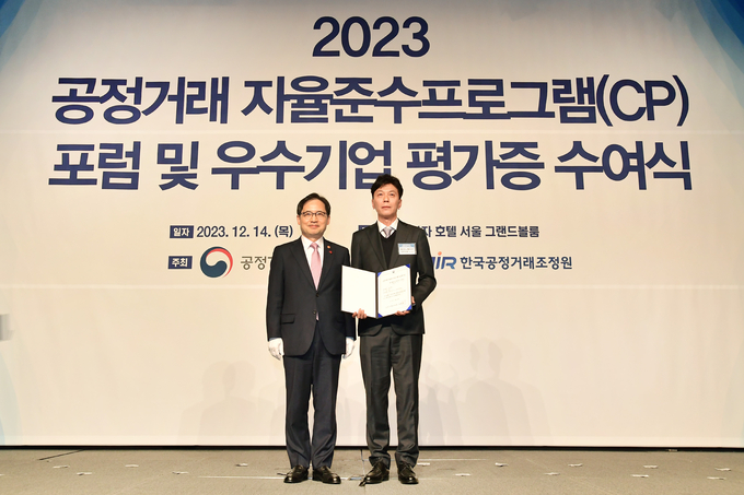 14일 서울 중구 더 플라자호텔에서 열린 CP 우수기업 평가증 수여식에서 선우성윤 SK이노베이션 컴플라이언스 담당(오른쪽)이 한기정 공정거래위원장과 기념촬영을 하고 있다.(사진=SK이노베이션)