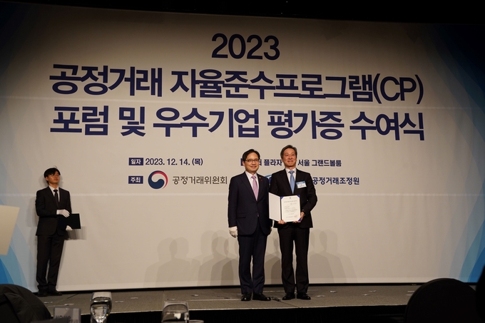 DL㈜ 자율준수관리자 신현식 전무가 공정거래위원회 한기정 위원장으로부터 우수기업 평가증을 수상하고 있다.(사진=DL그룹)