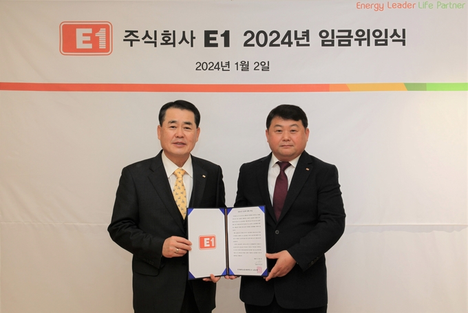 2일 서울 용산구 소재 E1 본사에서 구자용 E1 회장(왼쪽)과 박승규 E1 노조위원장(오른쪽)이 2024년도 임금에 관한 위임장을 들고 기념 촬영을 하고 있다.(사진=E1)