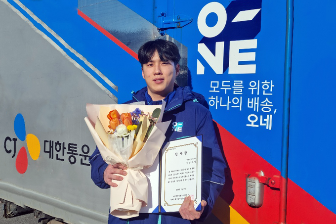 CJ대한통운 택배기사 정보교씨가 지난해 12월 번동에서 화재를 막은 공로로 수령한 감사장을 들고 기념사진 촬영을 하고 있다.(사진=CJ대한통운)