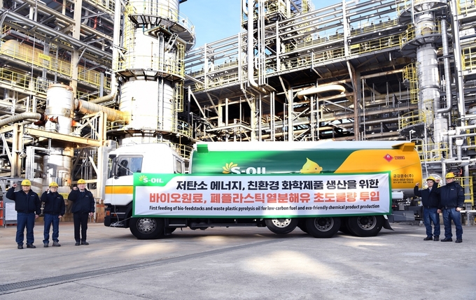 S-OIL 온산공장에서 바이오 원료와 폐플라스틱 열분해유를 실은 탱크로리의 하역 작업에 앞서 근무자들이 기념촬영을 하고 있다.(사진=S-OIL)