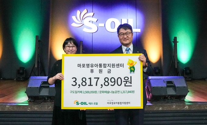 S-OIL 김광남 부문장(오른쪽)과 마포영유아통합지원센터 시소와그네 임명연 관장이 지난달 31일 S-OIL 본사에서 열린 ‘구도일 카페 및 문화나눔공연 모금액 전달식’에서 기념사진을 찍고 있다.(사진=S-OIL)