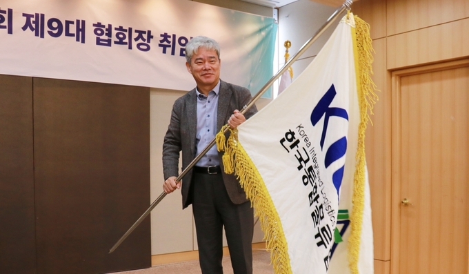지난 28일 한국통합물류협회 제9대 협회장 취임식에서 신영수 협회장이 협회기를 이양받아 흔들고 있다.(사진=CJ대한통운)
