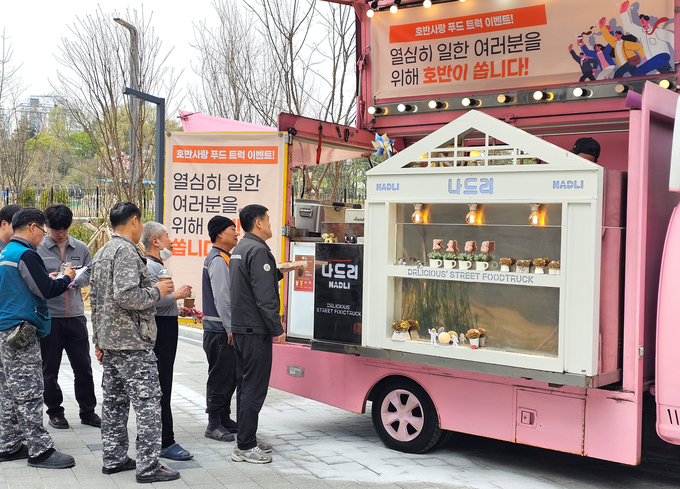 호반사랑 푸드 트럭 이벤트에 참여하고 있는 임직원들 모습(사진=호반그룹)