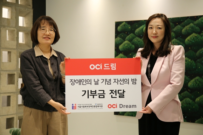 18일 OCI 본사에서 열린 ‘다 함께 드림’ 자선행사에서 이지현 OCI드림 대표(오른쪽)가 신연화 서울시립북부장애인종합복지관 관장에게 기부금을 전달한 후 기념사진을 촬영하고 있다.(사진=OCI)