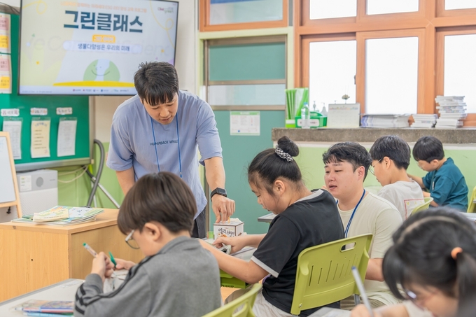 일일 선생님이 된 LG화학 임직원이 아이들과 멸종위기생물 무드등 만들기 체험을 하고 있다(사진=LG화학) 