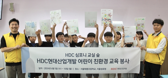 HDC현대산업개발은 지난 5일 심포니 교실 숲 조성 활동의 일환으로 노원구에 있는 태릉초에서 친환경 교육 봉사를 진행하고 기념사진을 촬영했다.(사진=HDC현대산업개발)