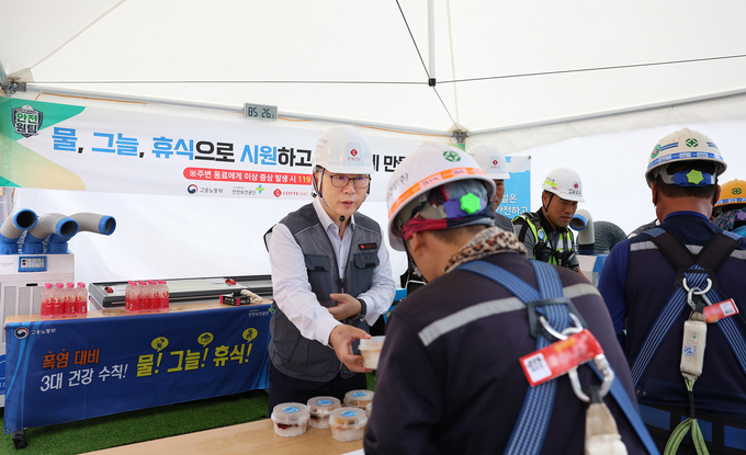 롯데건설 박현철 부회장이 혹서기를 맞아 ‘천안 롯데캐슬 더 청당 현장’에서 근로자들에게 팥빙수, 건강음료, 혹서기 용품 등을 나눠주고 있다(사진=롯데건설)