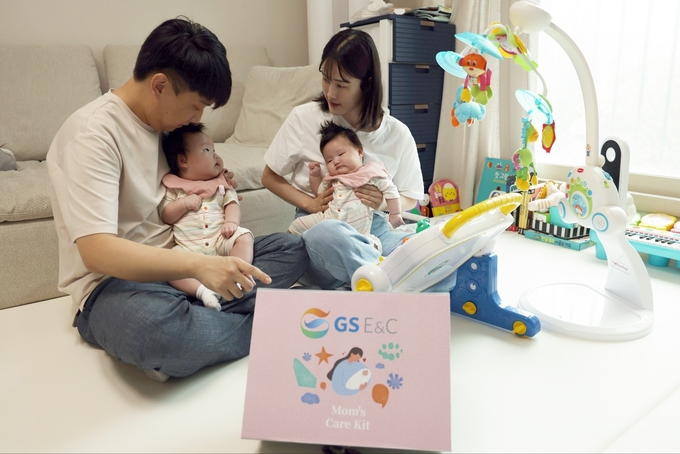 최근 쌍둥이 자녀를 출산해 육아휴직 중인 GS건설 직원(사진 왼쪽)이 아내와 함께 회사에서 준비한 출산축하선물을 받고 활짝 웃고 있다. (사진=GS건설)