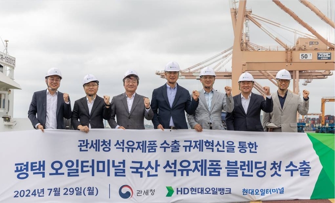  블렌딩 수출 현장에 참석한 이승수 HD현대오일뱅크 글로벌 사업본부장(왼쪽 4번째)과 고석진 관세청 통관국장(왼쪽 5번째)이 기념사진을 찍고 있다.(사진=HD현대오일뱅크)