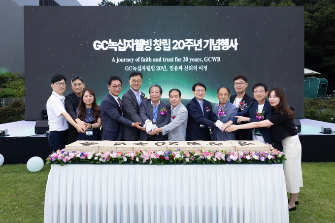 허일섭 GC회장(오른쪽에서 다섯번째)과 김상현 GC녹십자웰빙 대표(왼쪽에서 네번째) 및 임직원들이 창립 20주년 기념<br>
식을 갖고 축하 떡을 자르고 있다.