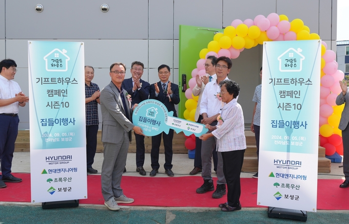 전라남도 보성군에서 진행한 '기프트하우스 캠페인' 집들이 행사에서 현대엔지니어링 엄홍석 커뮤니케이션 실장(왼쪽)과 수혜자가 기념사진을 촬영하고 있다.