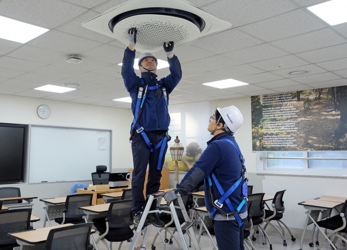 삼성전자서비스 엔지니어들이 수능 시험장에 설치된 삼성전자 시스템에어컨을 사전점검하는 모습