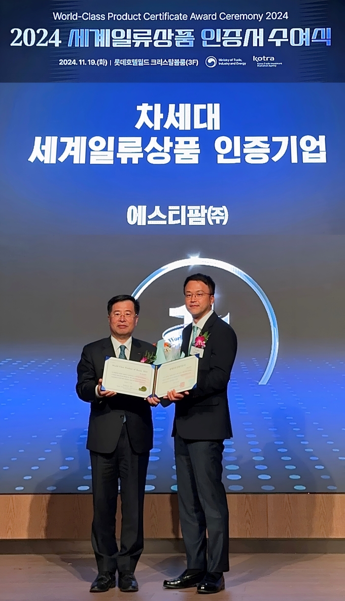  에스티팜이 차세대 세계일류상품 생산기업으로 선정돼 인증서를 수여 받았다. 강경성 KOTRA 사장(왼쪽)과 김이환 에스티팜 상무(오른쪽).