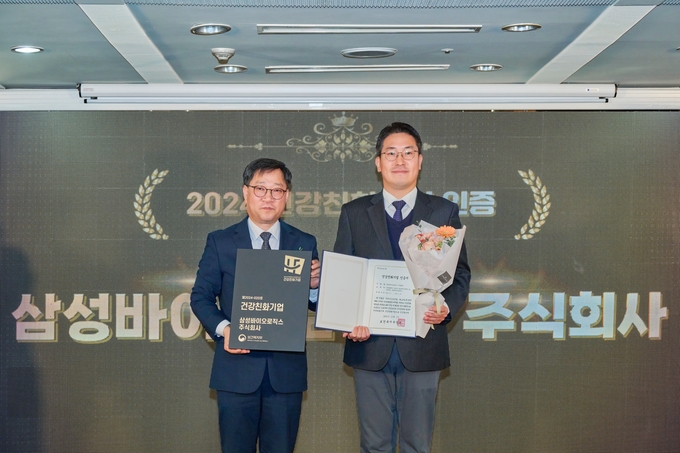 삼성바이오로직스는 2024년 건강친화기업 인증제도 성과대회에서 ’2024 건강친화기업‘ 인증을 획득했다. 사진은 정윤순 보건복지부 보건의료정책실장(왼쪽)과 김현민 삼성바이오로직스 안전환경팀 환경그룹장(오른쪽)