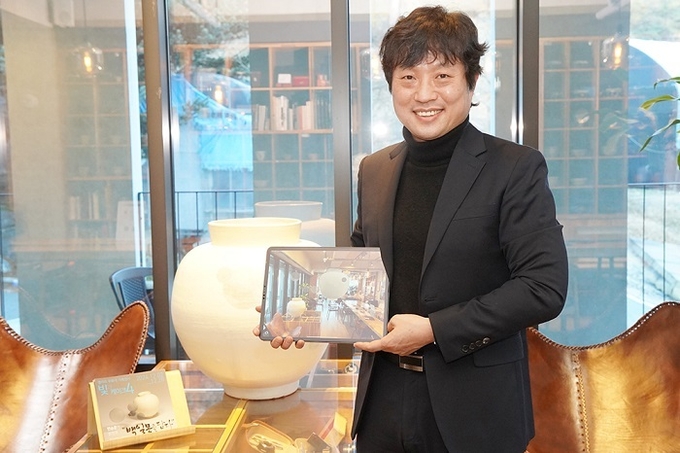 서영호 아이씨에프 대표가 변승훈 작가의 작품을 자사 AR(증강현실) 애플리케이션 ‘에이알쿠키’로 보여주고 있다. / 사진=아이씨에프 제공